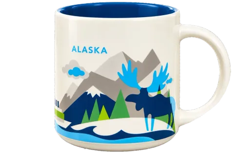 The Alaska mug: cream ceramic with a blue inside, illustrated mountains, evergreens and a moose