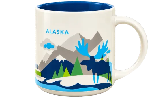 The Alaska mug: cream ceramic with a blue inside, illustrated mountains, evergreens and a moose