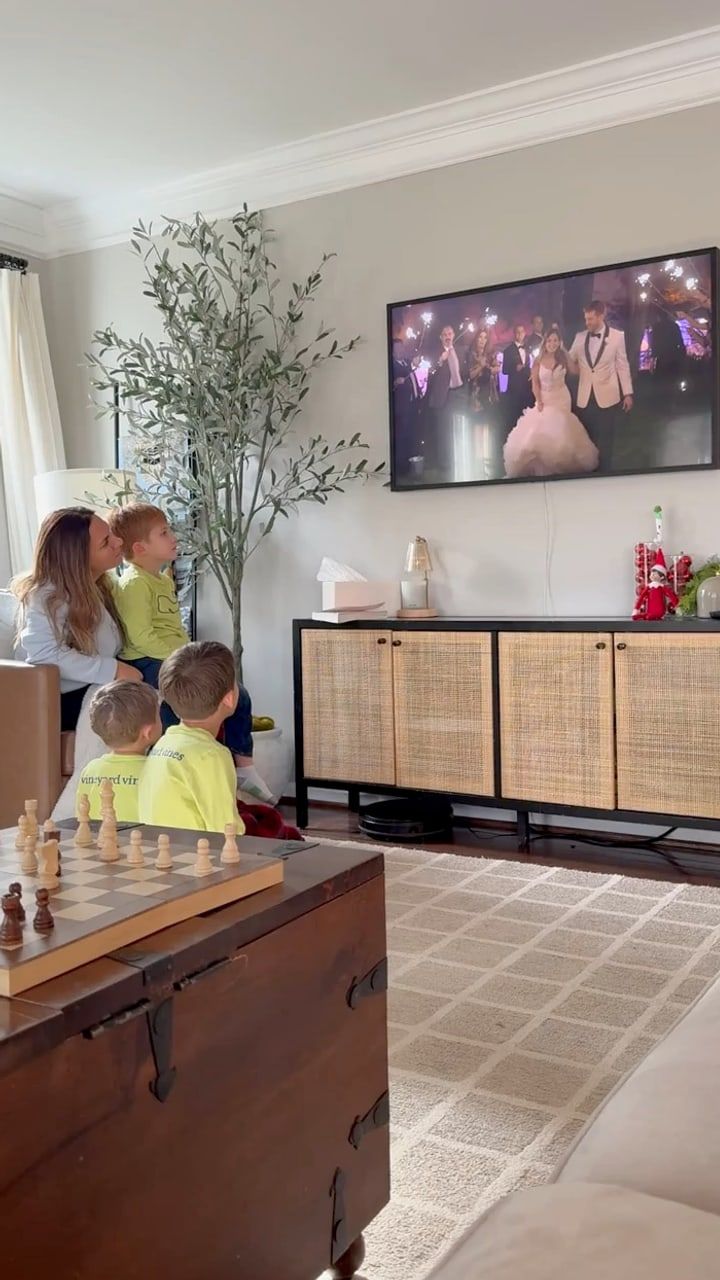 Areizo and Tom's kids watching their parents' wedding film on the living room TV