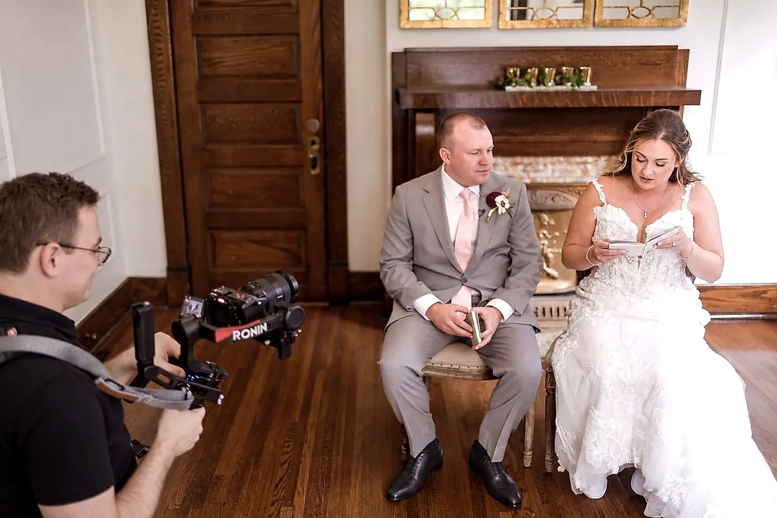Brian filming Nicole and Jeff's private vows at CJ's Off the Square, his camera rig in the foreground as Nicole reads from a small book