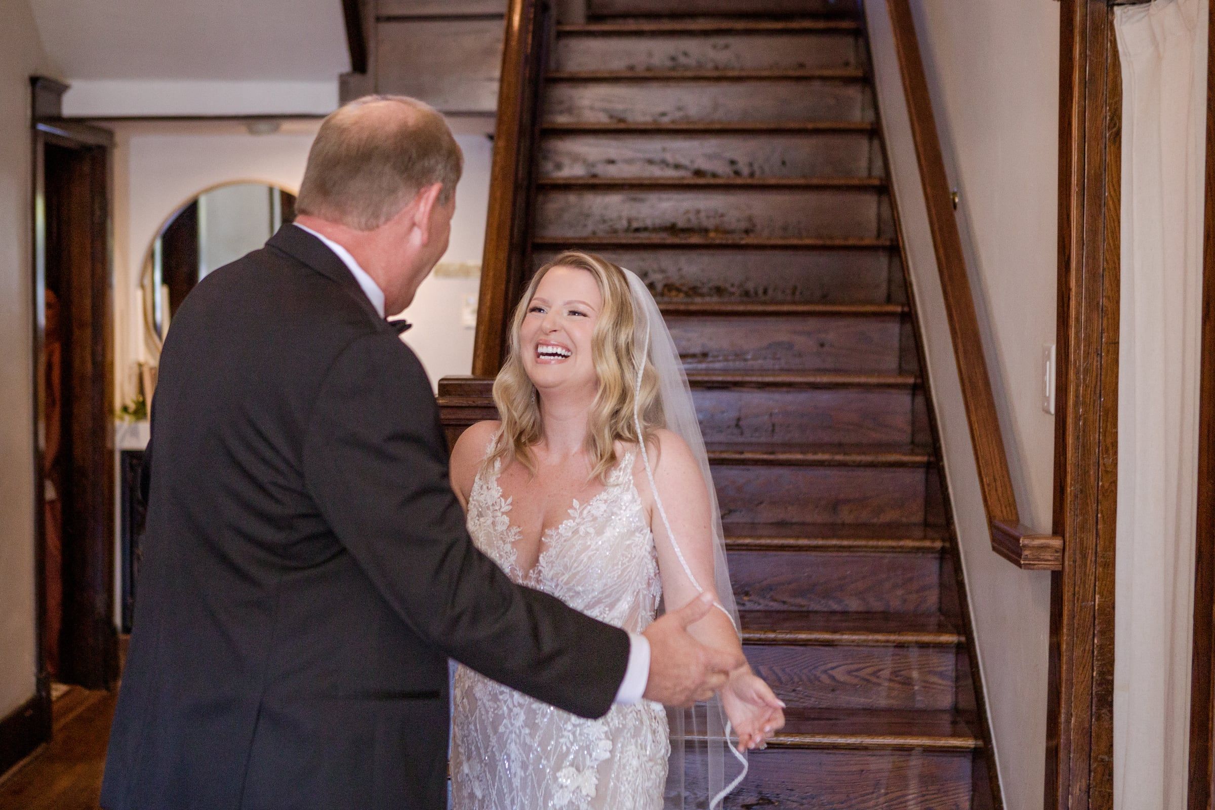 Caitlin laughs as she reaches the bottom of the stairs and her dad greets her with open arms