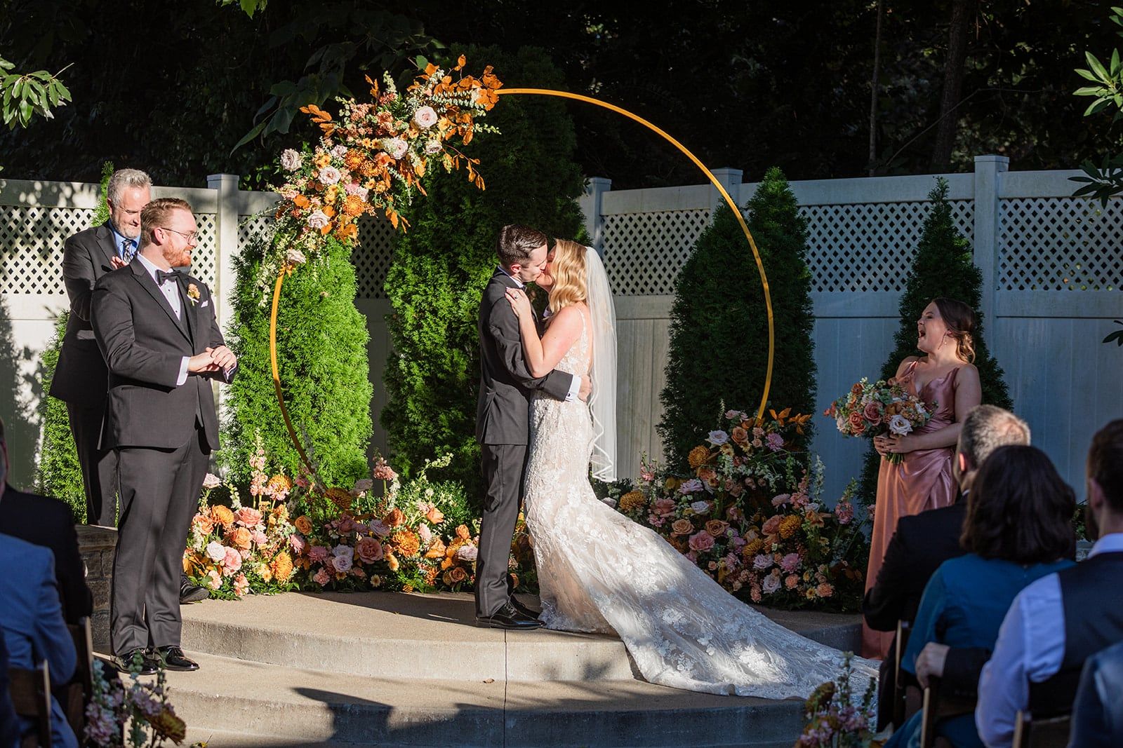 Caitlin and Gunnar's first kiss under the gold arch as guests watch