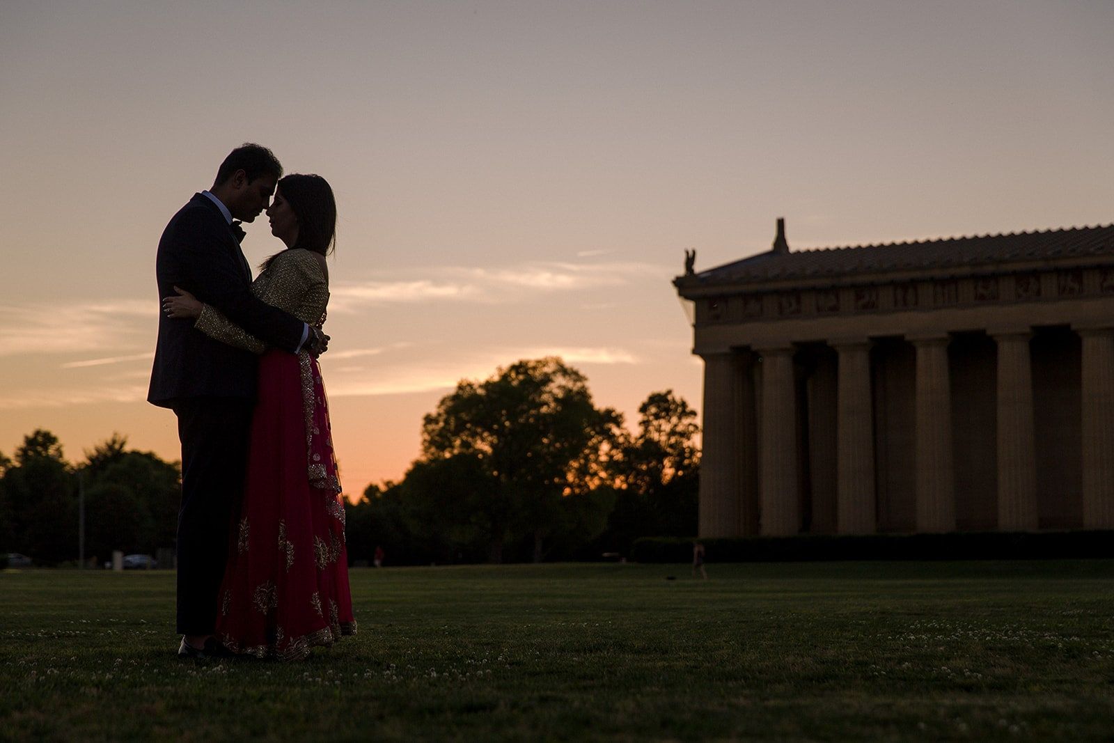 Couple silhouetted at sunset beside the Parthenon in Nashville’s Centennial Park