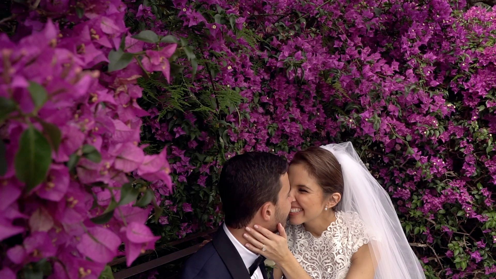 Veronica and Massimo kiss in the back of an open vintage car as guests and an accordion player celebrate around them
