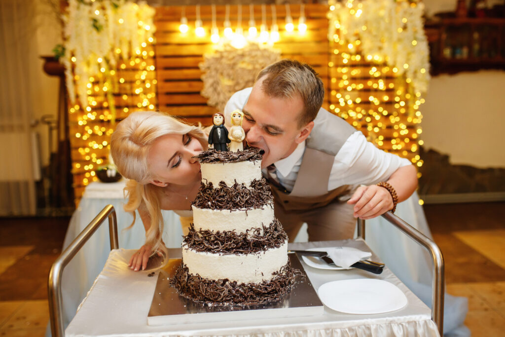 Meredith and Arnold take a big bite out of their cake without forks captured by Nashville photographer With This Ring Wedding Films + Photo.