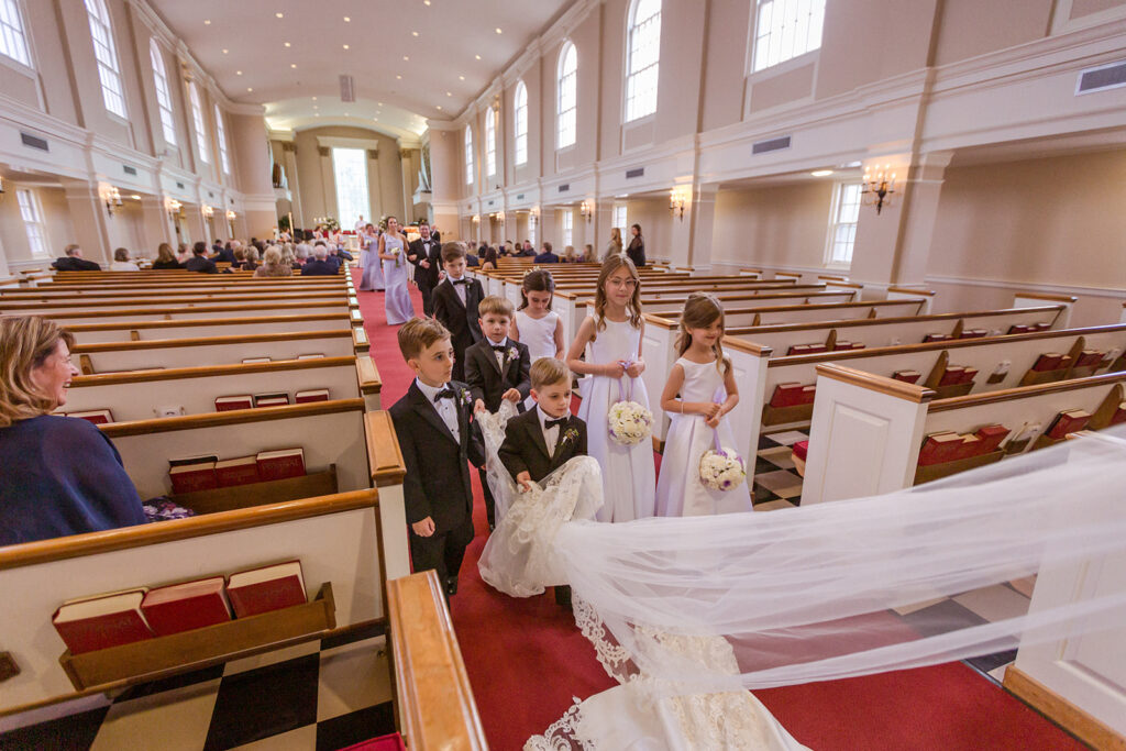 flower girls and ring bearers carry Sarah Beth's wedding veils at her Nashville wedding