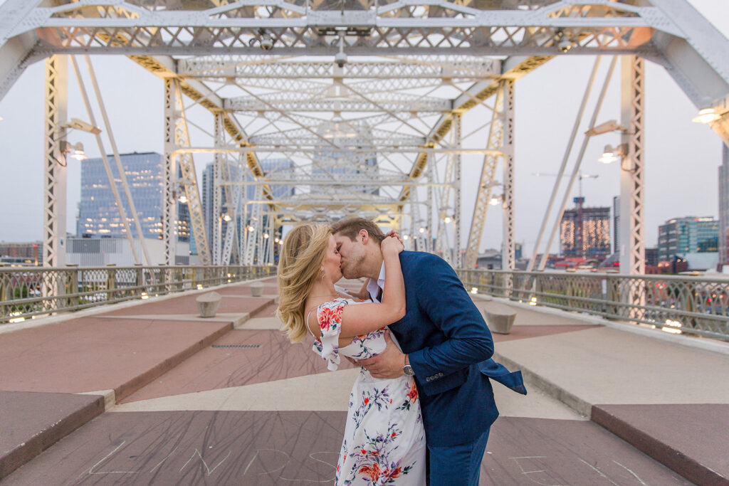 A beautiful bride and groom share a kiss at popular Nashville photo shoot location the Pedestrian Bridge.  Great for engagement shoots.