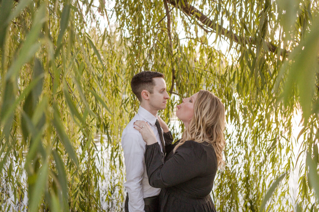 Groom Gunnar and bride Caitlin share a fun candid photography moment under the trees during their Nashville engagement photo session.