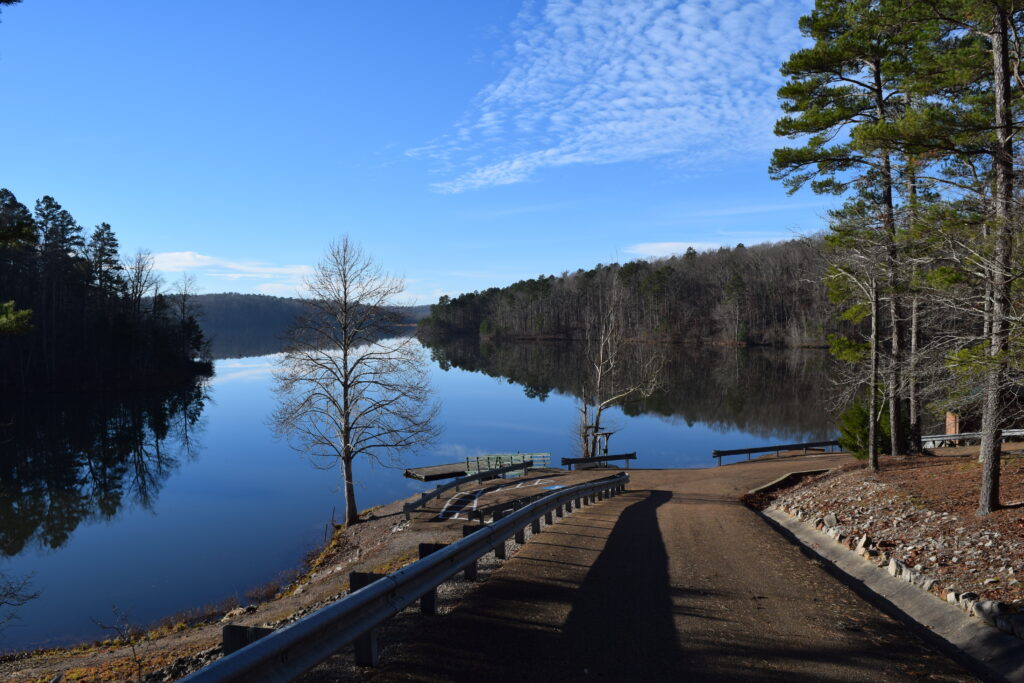 Peaceful view of Travis McNatt Lake at Big Hill Pond State Park in Tennessee, with calm reflective water, forested shoreline, and open sky — a quiet and scenic location for outdoor wedding photography and tranquil wedding film backdrops.